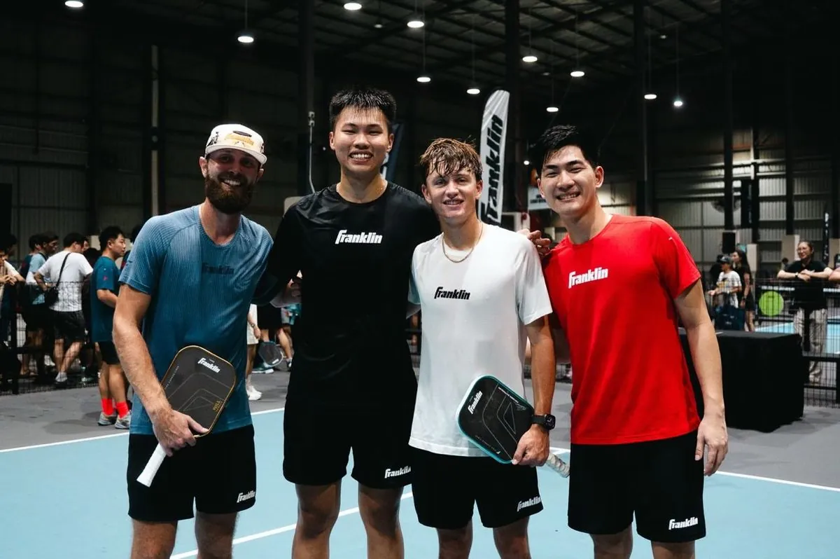Players posing on court with Franklin paddles